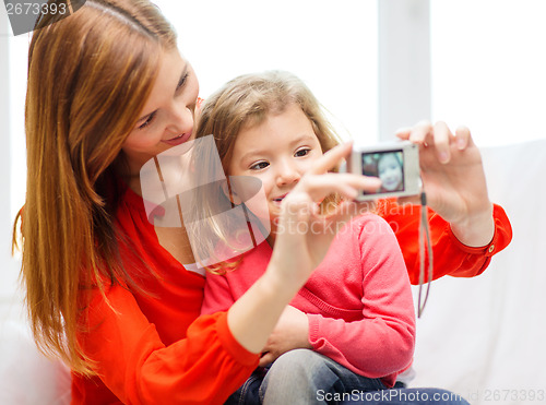 Image of smiling mother and daughter taking picture