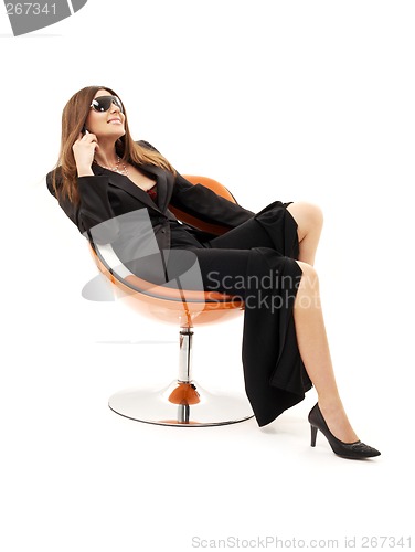 Image of businesswoman with phone in orange chair