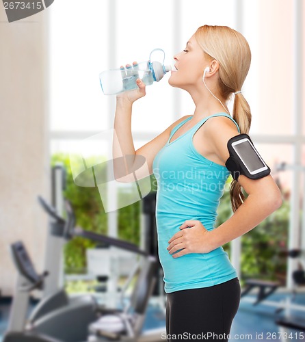 Image of sporty woman running with smartphone and earphones