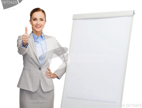 Image of smiling businesswoman standing next to flip board