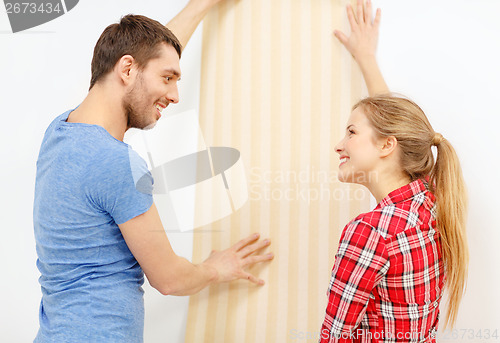 Image of smiling couple choosing wallpaper for new home