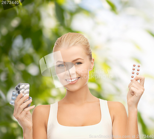 Image of smiling young woman with pills