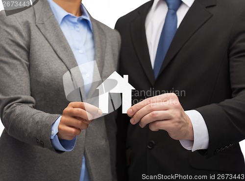 Image of businessman and businesswoman holding white house