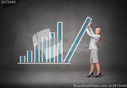 Image of young smiling businesswoman pushing up chart bar