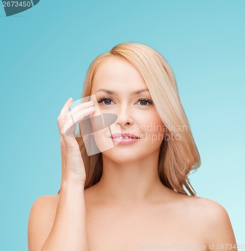 Image of beautiful woman touching her eye area