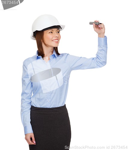 Image of businesswoman in helmet writing on virtual screen