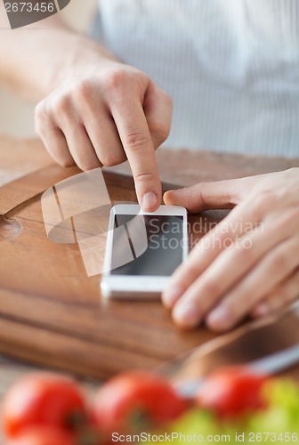 Image of closeup of man pointing finger to smartphone