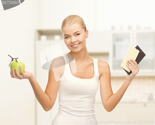 Image of sporty woman with apple and chocolate bars