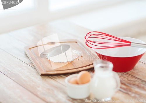 Image of jugful of milk, eggs in a bowl and flour