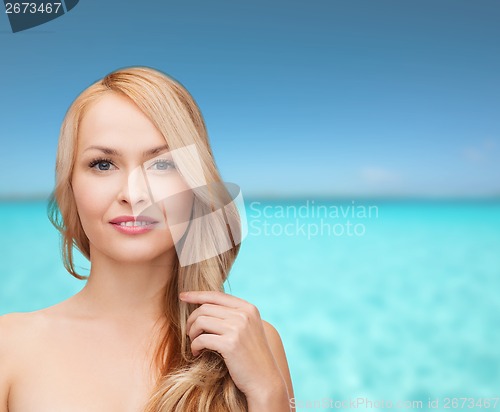 Image of beautiful woman playing with long hair