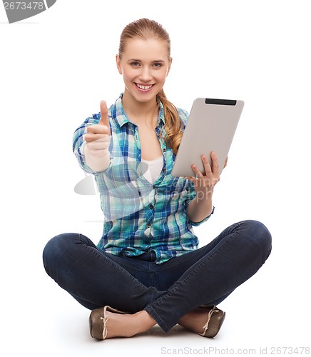 Image of young woman in casual clothes sitting on floor