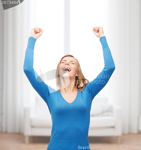 Image of laughing young woman with hands up