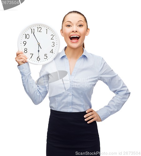 Image of attractive businesswoman with wall clock