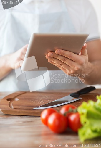 Image of closeup of man pointing finger to tablet pc