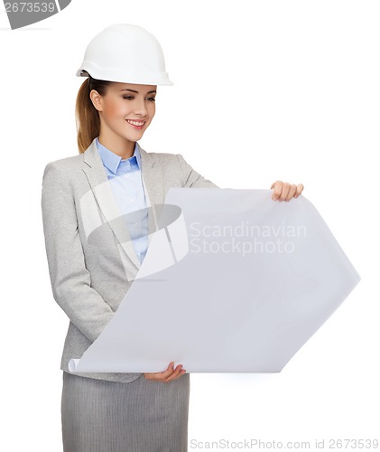 Image of smiling architect in white helmet with blueprints