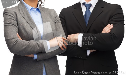 Image of businesswoman and businessman with crossed arms