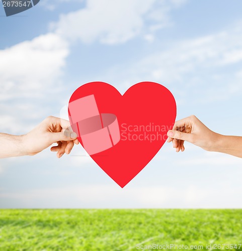 Image of couple hands holding red heart