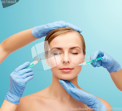 Image of woman face and beautician hands with syringe