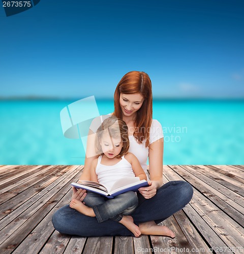Image of happy mother with adorable little girl and book
