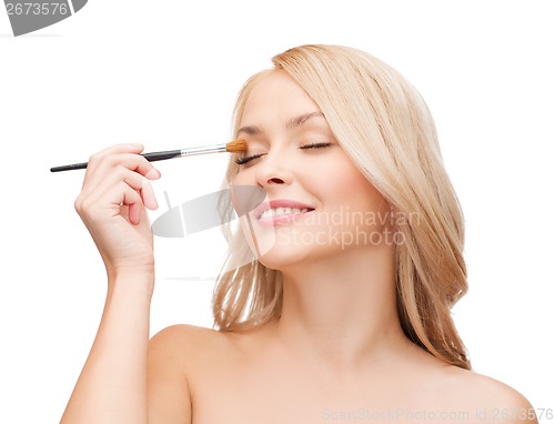 Image of beautiful woman with closed eyes and makeup brush