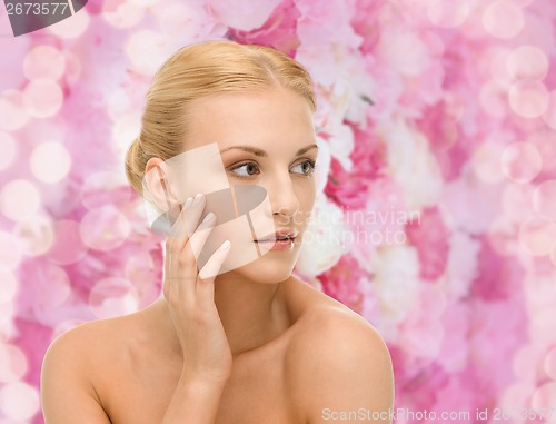 Image of beautiful woman touching her face skin