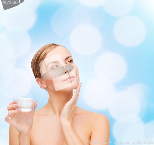 Image of woman applying cream on her skin