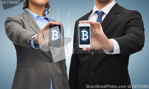 Image of businessman and businesswoman with smartphones