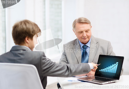 Image of older man and young man with laptop computer