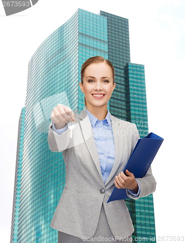 Image of smiling businesswoman with folder and keys