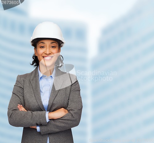 Image of businesswoman in white helmet with crossed arms