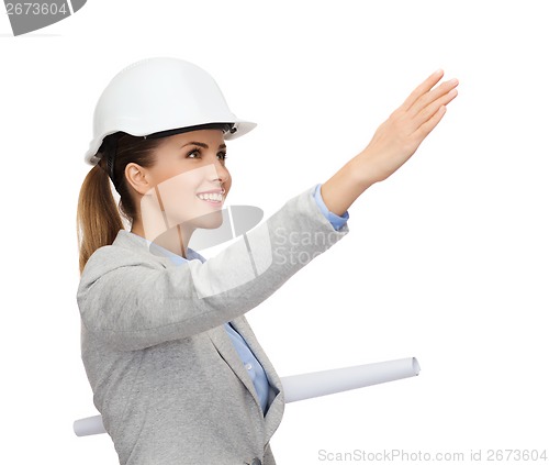 Image of smiling architect in white helmet with blueprints