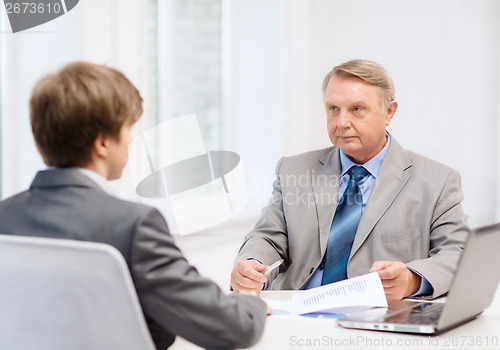 Image of older man and young man having meeting in office