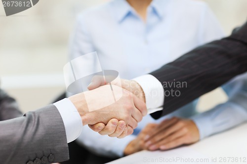 Image of two businessmen shaking hands in office