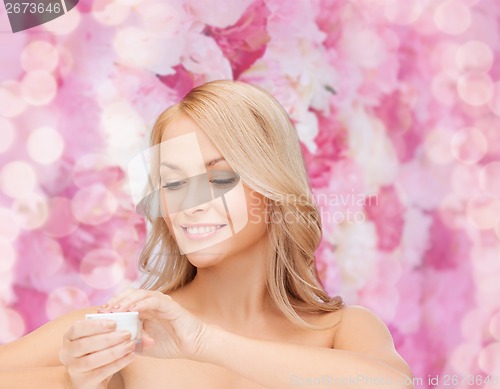 Image of beautiful woman applying cream