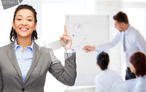 Image of smiling businesswoman with her finger up at office