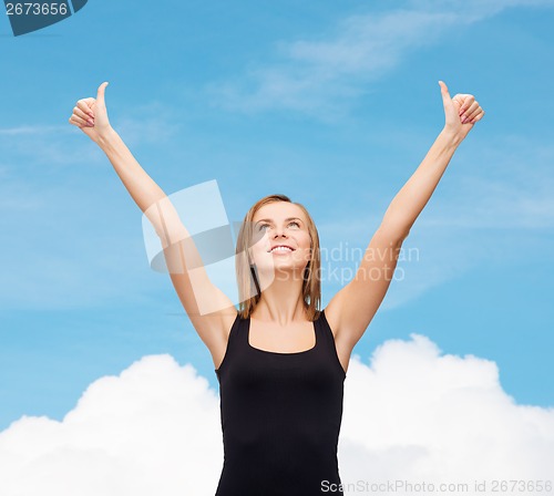 Image of woman in blank black tank top showing thumbs up