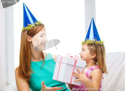 Image of mother and daughter in blue hats with favor horns