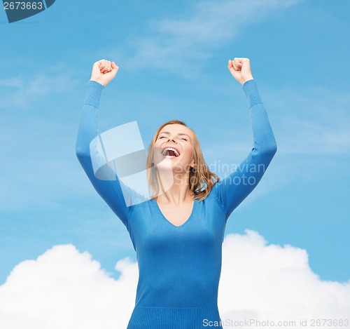 Image of laughing young woman with hands up