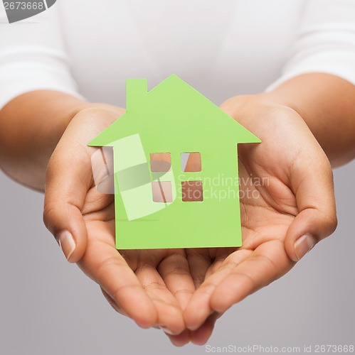 Image of woman hands holding green house