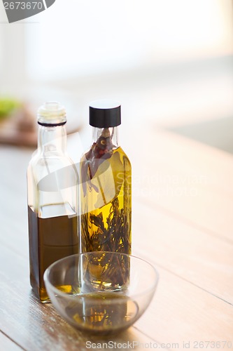 Image of close up of two olive oil bottles and bowl of oil