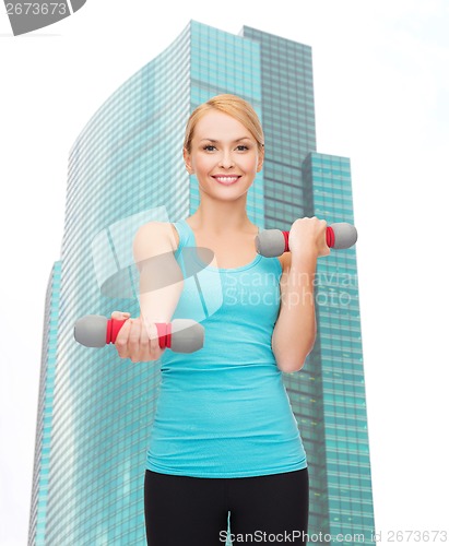 Image of young sporty woman with light dumbbells