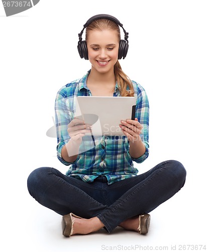 Image of young woman in casual clothes sitting on floor