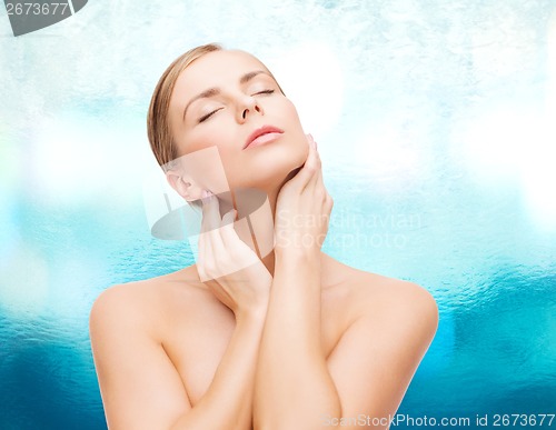 Image of beautiful woman touching her face with closed eyes