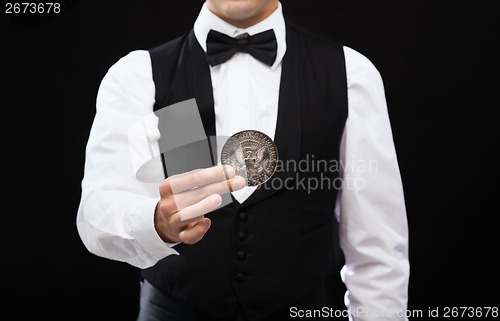 Image of dealer holding half dollar coin