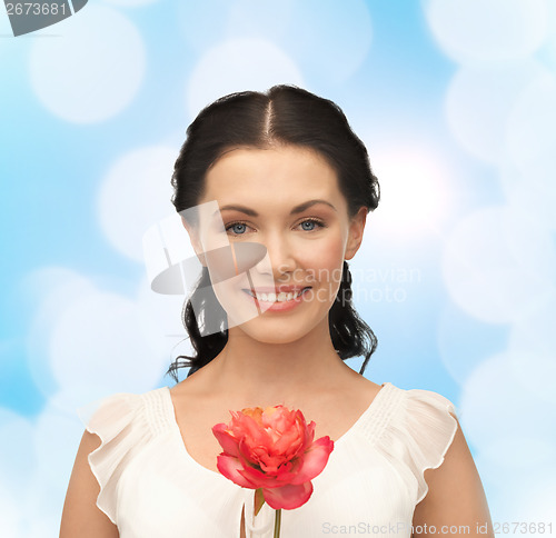 Image of young and beautiful woman with flower