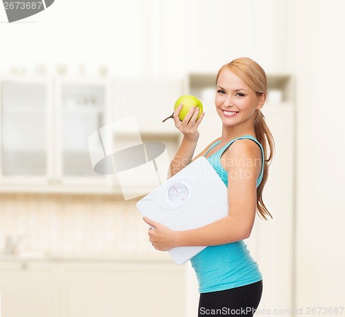 Image of sporty woman with scale and green apple