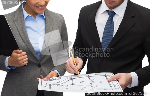 Image of businesspeople with clipboard, blueprint, helmet