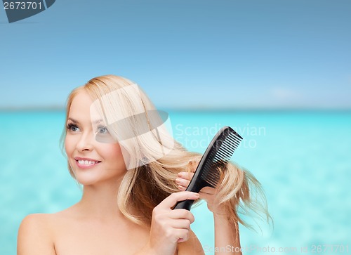 Image of smiling woman with hair brush