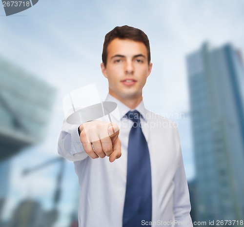 Image of friendly young buisnessman pointing finger