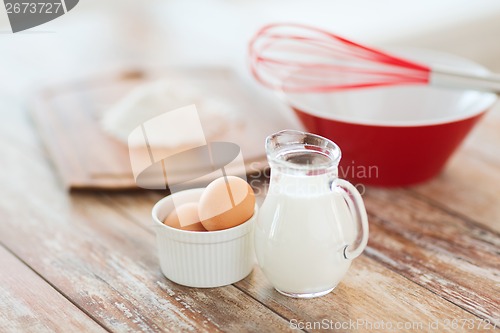 Image of jugful of milk, eggs in a bowl and flour